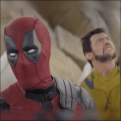 A Man In A Deadpool Costume Stands Next To A Man In A Yellow Jacket GIF