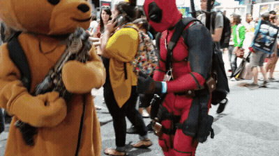 A Man In A Deadpool Costume Stands Next To A Teddy Bear GIF