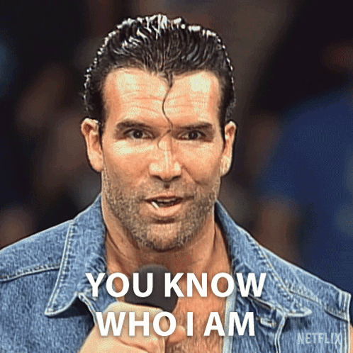 A Man In A Denim Jacket Is Holding A Microphone And Says " You Know Who I Am " GIF