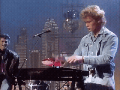 A Man In A Denim Jacket Is Playing A Keyboard GIF