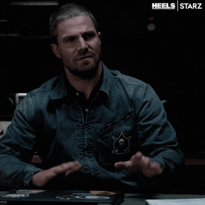 A Man In A Denim Jacket Is Sitting At A Table With A Laptop On It And The Words Heels Starz On The Bottom GIF