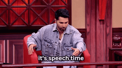 A Man In A Denim Jacket Is Sitting In A Chair With The Words It 'S Speech Time Below Him GIF