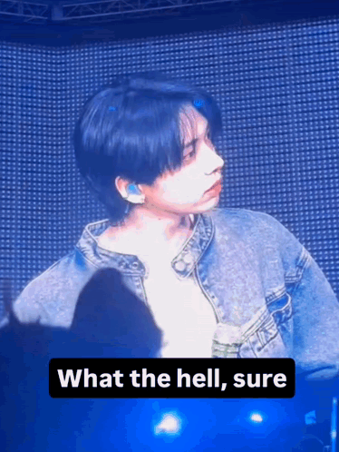 A Man In A Denim Jacket Is Standing In Front Of A Crowd And Says " What The Hell Sure " GIF