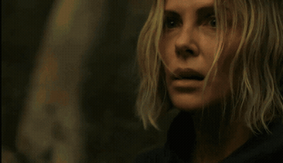 A Man In A Denim Jacket Is Standing In The Woods With Trees In The Background GIF
