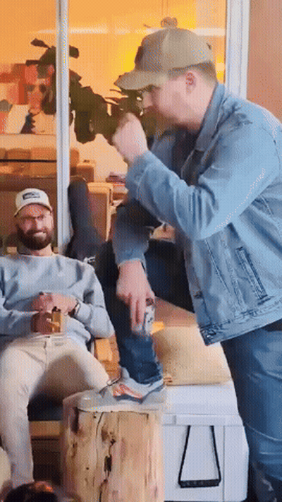 A Man In A Denim Jacket Is Standing Next To A Man In A Baseball Cap GIF