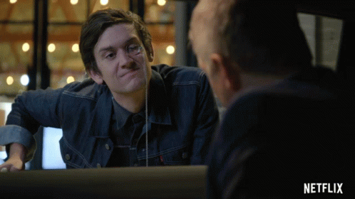 Man In Denim Jacket Looking In Mirror With Netflix Logo GIF