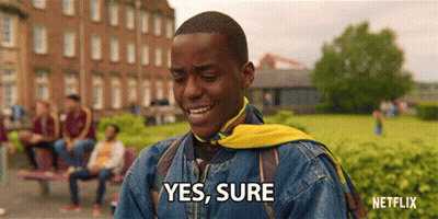A Man In A Denim Jacket With A Yellow Scarf Around His Neck Says " Yes Sure " GIF