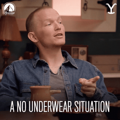 A Man In A Denim Shirt Is Sitting At A Table With A No Underwear Situation Written Below Him GIF