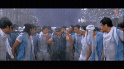 A Man In A Denim Shirt Is Standing In A Crowd Of Men GIF