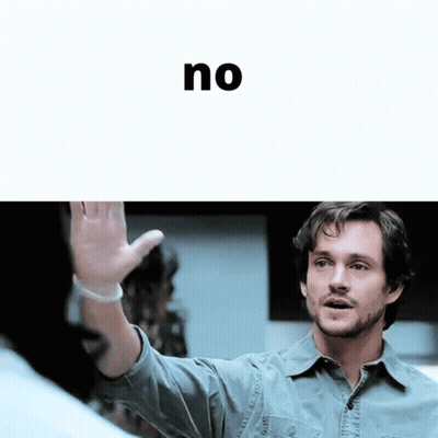 A Man In A Denim Shirt Is Waving His Hand In Front Of The Word No GIF