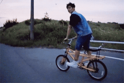 A Man In A Denim Vest Is Riding A Yellow Bike GIF