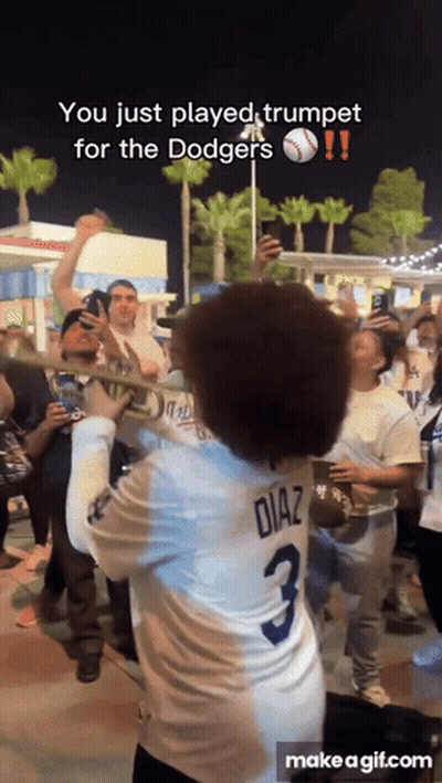 A Man In A Diaz Jersey Plays Trumpet In Front Of A Crowd GIF
