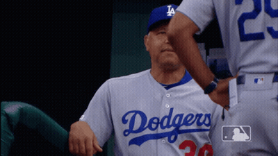 A Man In A Dodgers Jersey Is Being Hugged By Another Man GIF