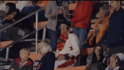 A Man In A Elvis Costume Stands In The Stands GIF