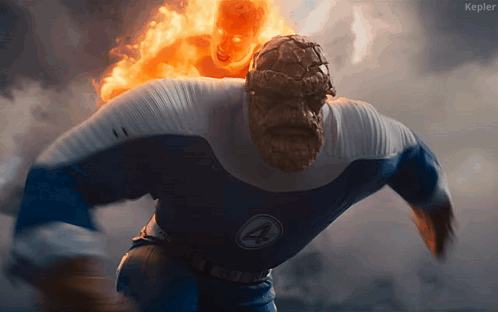 A Man In A Fantastic Four Costume Is Running With A Ghost Rider Behind Him GIF