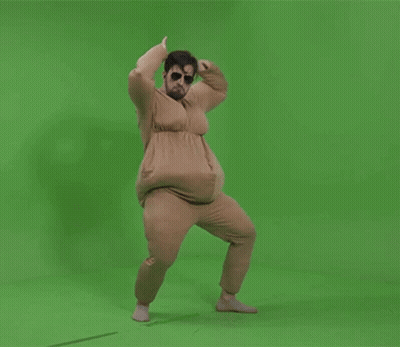 A Man In A Fat Suit Is Dancing On A Green Background GIF