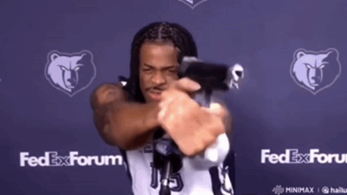 A Man In A Fedex Forum Jersey Is Holding A Gun GIF