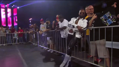 A Man In A Finesse Shirt Stands In Front Of A Crowd Of People GIF