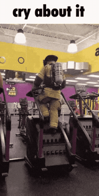 A Man In A Fire Suit Is Riding A Treadmill In A Gym And The Caption Says Cry About It GIF