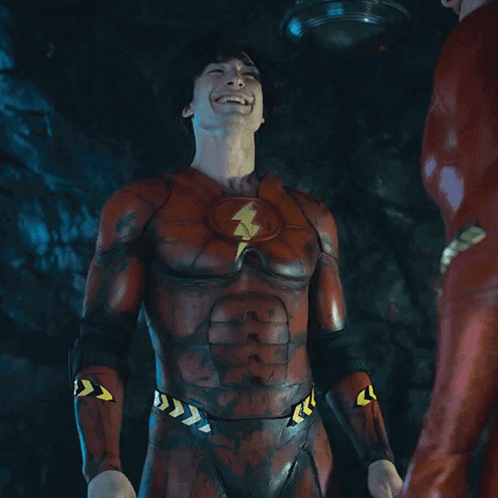 A Man In A Flash Costume Is Laughing With The Word Yeah Behind Him GIF