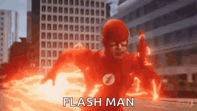 A Man In A Flash Suit Is Running Through A City While Holding A Gun . GIF
