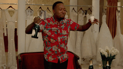 A Man In A Floral Shirt Holds A Bottle Of Champagne And A Glass GIF