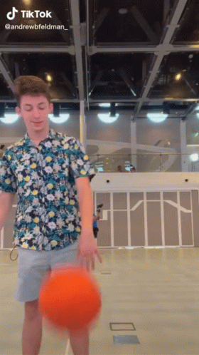 A Man In A Floral Shirt Is Holding A Basketball In His Hand And A Tiktok Watermark Is Visible GIF