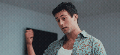 a man in a floral shirt is holding his fist up
