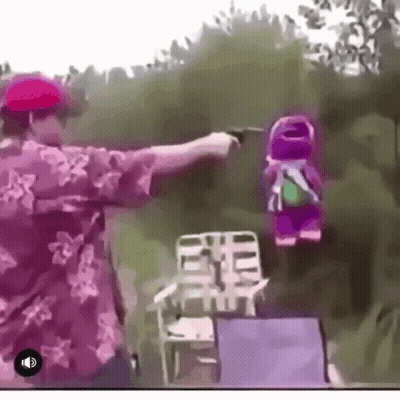 A Man In A Floral Shirt Is Pointing A Gun At A Stuffed Animal GIF