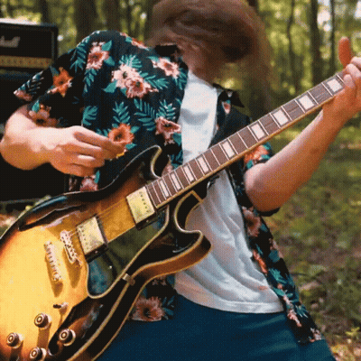 A Man In A Floral Shirt Playing A Guitar GIF