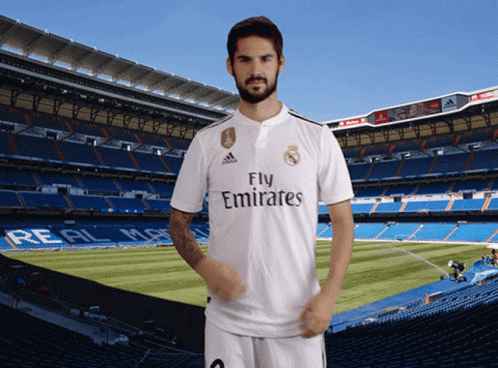 A Man In A Fly Emirates Jersey Stands In Front Of A Soccer Field GIF