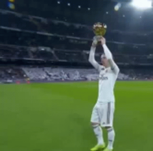 A Man In A Fly Emirates Shirt Is Holding A Trophy GIF