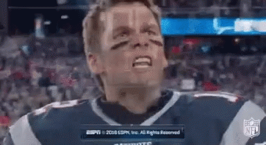 A Man In A Football Uniform Is Making A Funny Face While Standing In Front Of A Crowd . GIF