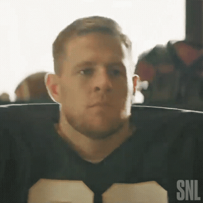 A Man In A Football Uniform Is Sitting In A Chair Looking At The Camera . GIF