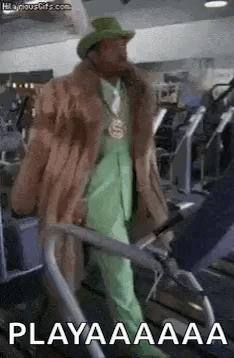 A Man In A Fur Coat And Hat Is Walking On A Treadmill . GIF