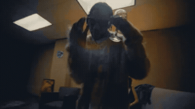 A Man In A Fur Coat And Sunglasses Holds A Glass Of Wine GIF