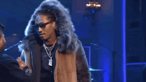 A Man In A Fur Coat Is Shaking Hands With Another Man In A Hat . GIF
