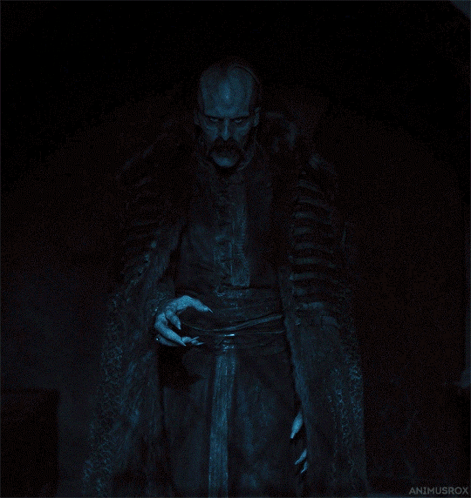 A Man In A Fur Coat Is Standing In The Dark With The Name Animusrox On The Bottom Left GIF