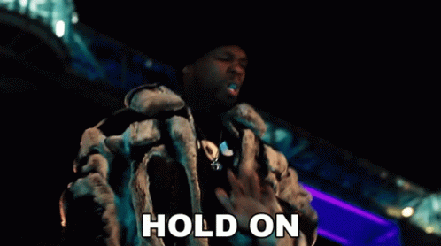 A Man In A Fur Coat Says Hold On GIF