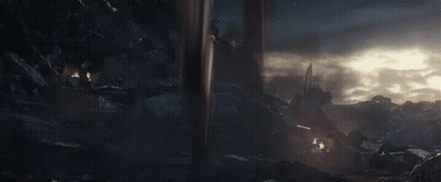 A Man In A Futuristic Suit With Wings Is Standing In The Dark GIF