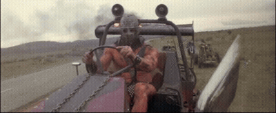 A Man In A Gas Mask Is Driving A Vehicle GIF