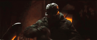 A Man In A Gas Mask Is Holding A Sword In His Hand . GIF
