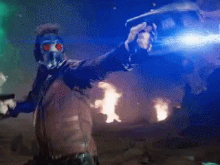 A Man In A Gas Mask Is Standing In Front Of A Fire GIF