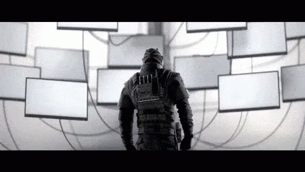 A Man In A Gas Mask Is Standing In Front Of A Wall Filled With Lots Of Empty Boxes . GIF