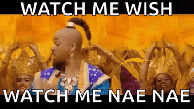 A Man In A Genie Costume Is Dancing In Front Of A Group Of People . GIF