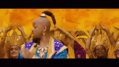 A Man In A Genie Costume Is Dancing In Front Of A Group Of Women . GIF