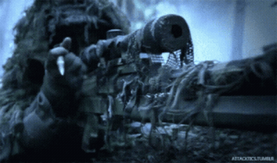 A Man In A Ghillie Suit Holding A Sniper Rifle With Attacktics.tumblr Written On The Bottom GIF