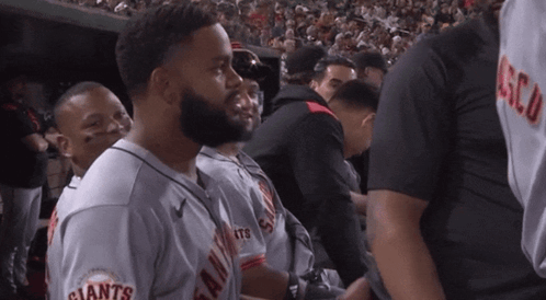 A Man In A Giants Jersey Stands In A Crowd GIF