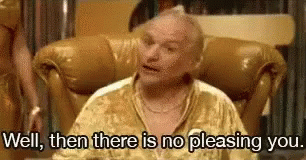 A Man In A Gold Shirt Is Sitting In A Chair And Says `` Well , Then There Is No Pleasing You . '' GIF