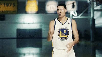 A Man In A Golden State Warriors Jersey Stands On A Court GIF